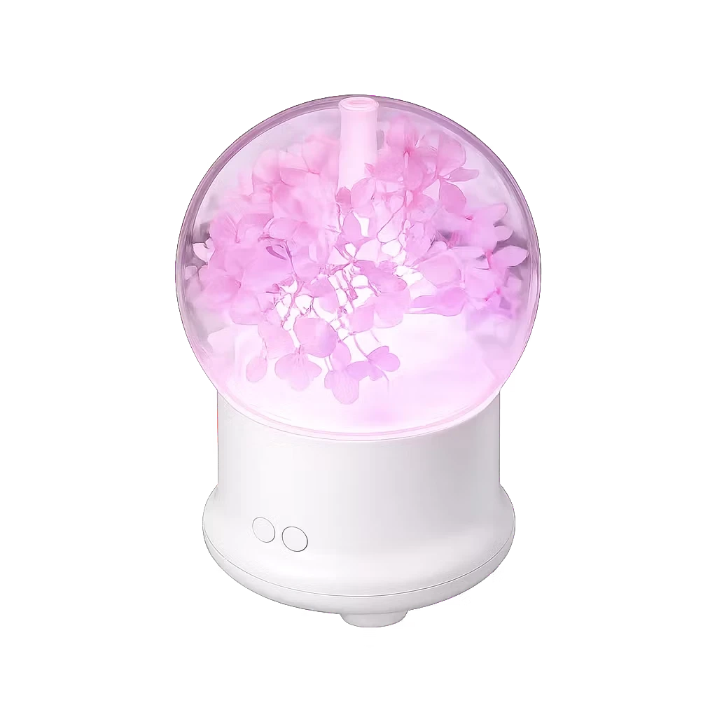 Roselle Wellness flower aromatherapy diffuser with pink preserved flowers inside a clear globe on a white base